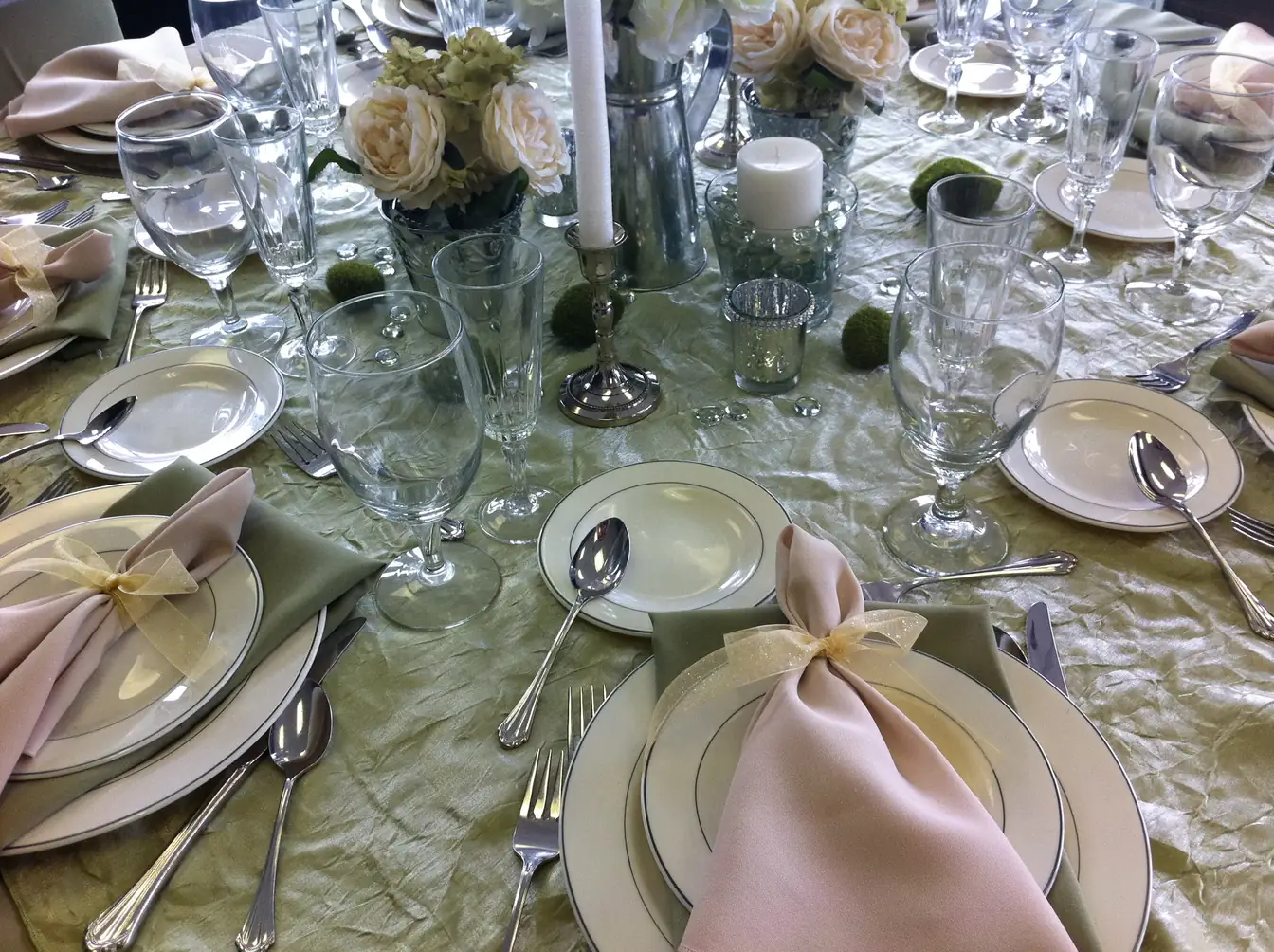 Sage crinkle linen with ivory china, flatware, and a folded blush napkin